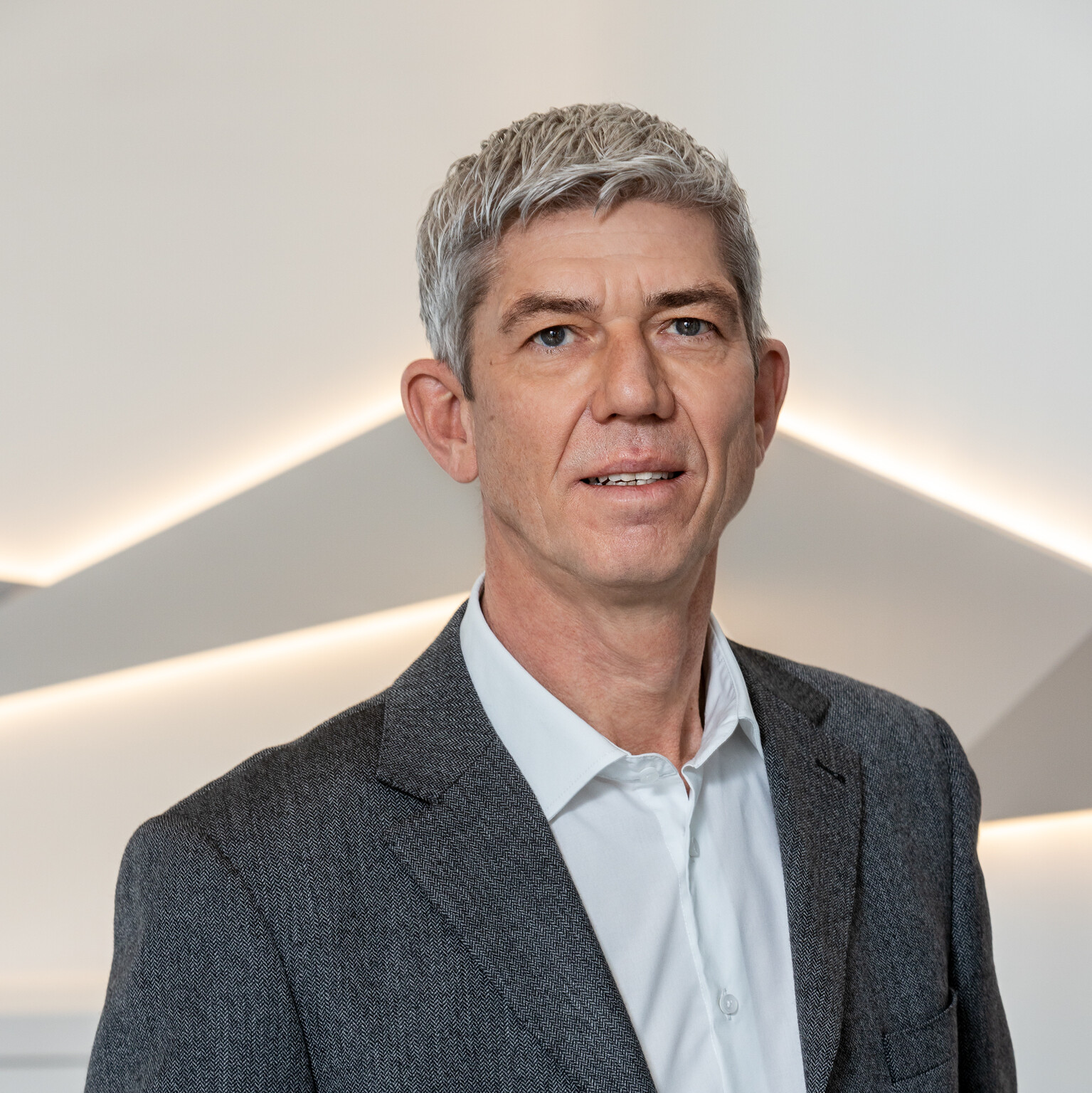 Ein Mann in einem Anzug bei einer Presseveranstaltung von CANCOM Austria.