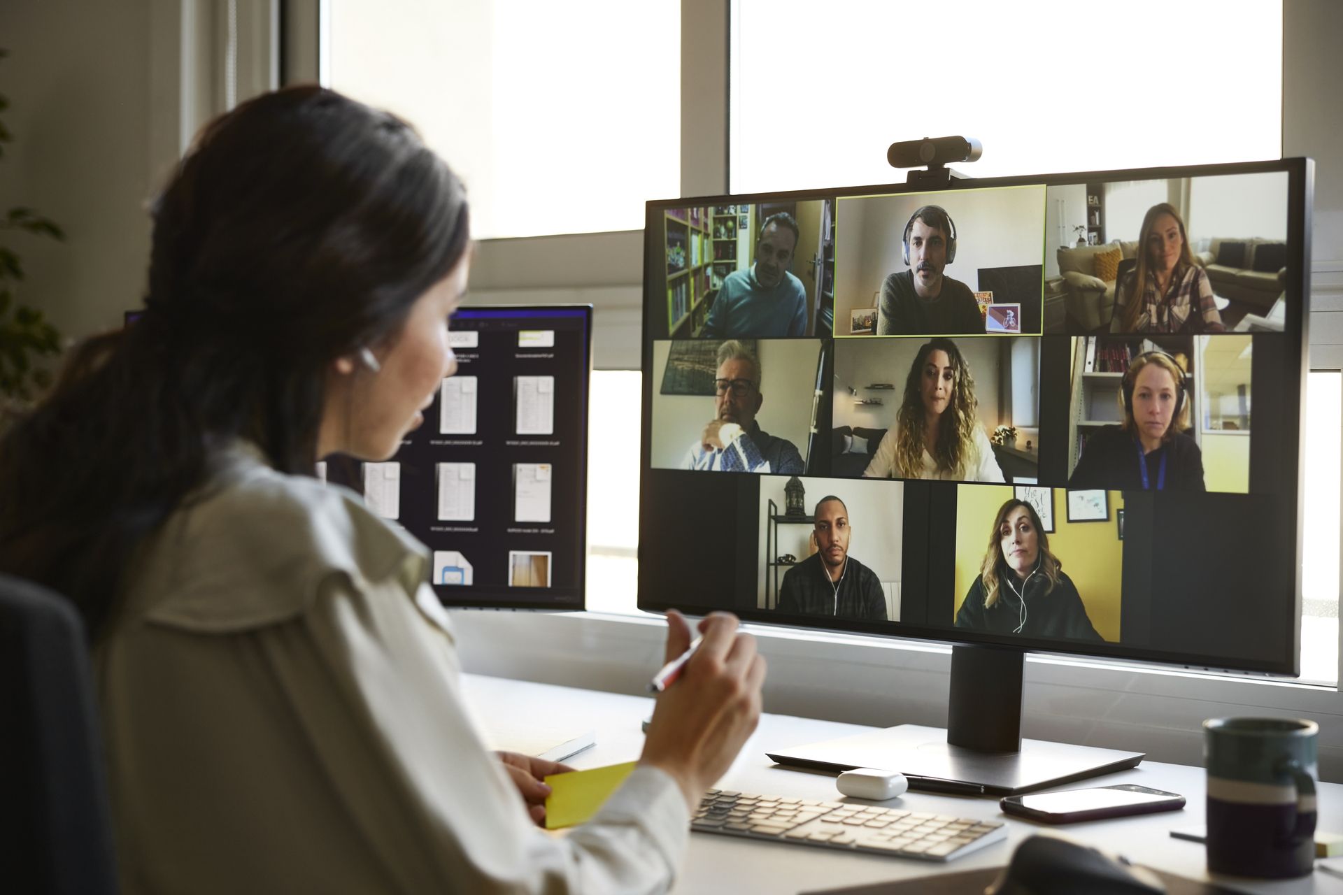 Frau betrachtet einen Computerbildschirm in einem Büro, arbeitet möglicherweise remote.